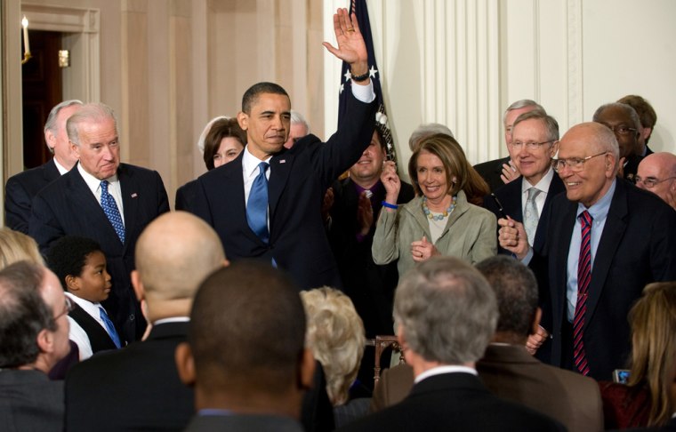 President Barack Obama waves alongside lawmakers after signing the healthcare insurance reform legislation during a ceremony in the East Room of the White House, March 23, 2010.