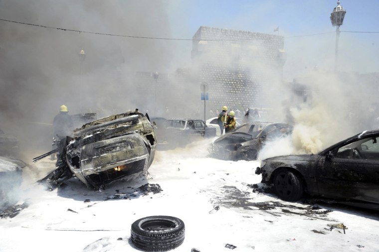 Civil Defense members extinguish fires on cars at the site of an explosion outside Syria's highest court in central Damascus on June 28, 2012. The explosion tore through the car park outside the court on Thursday, torching at least 20 cars, a Reuters witness said, but it was not immediately known if there were any casualties.