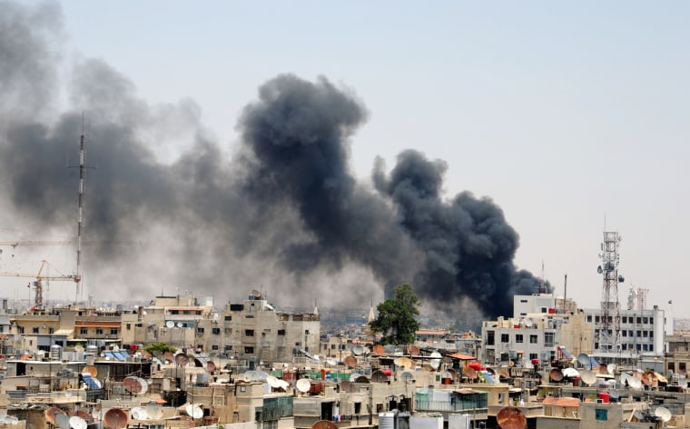 Smoke rises above Damascus after two huge bombs exploded outside the Palace of Justice in Central Damascus on June 28.