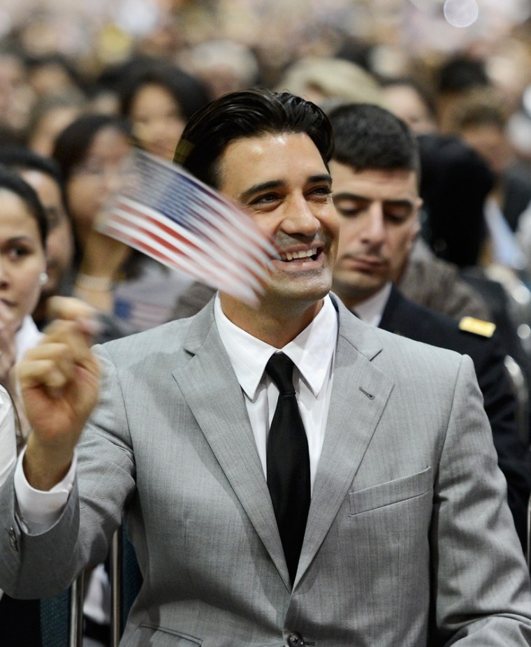 Gilles Marini waves a US flag after taking the oath of citizenship at a naturalization ceremony in Los Angeles on Wednesday.