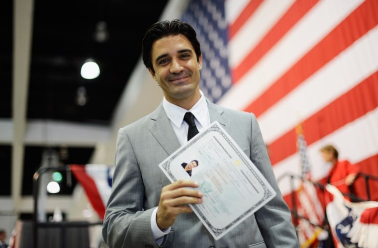 Marini holds up his US citizenship certificate after taking the oath on Wednesday.