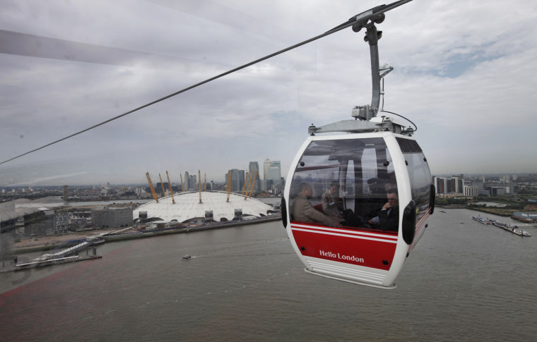 Back-dropped by the O2, a Transport for London's gondola lift cable car is seen across the River Thames, in London, on June 28. The cable car will make the half-mile crossing between Greenwich and the Royal Docks, allowing visitors to take in the views of Olympic Park, the Canary Wharf financial center and the Thames Barrier. Each of the 34 cars holds 10 people and looks like the gondolas that ferry skiers up the mountains in the Swiss Alps. Travelers can go one way or round-trip, with a one-way ticket costing 3.20 pounds (5 US dollars).