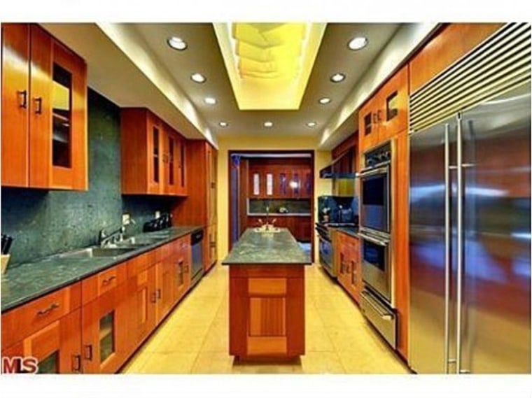 The galley kitchen has high-end finishes and stainless steel appliances.