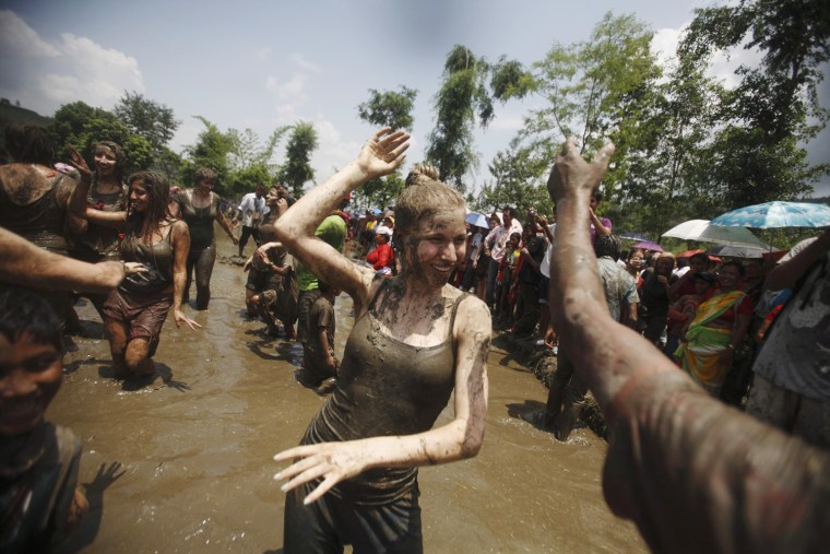 A tourist dances as she celebrates Asar Pandhra festival in Pokhara valley, west of Nepal's capital Kathmandu on June 29. Farmers in Nepal celebrate the festival to mark the commencement of rice crop planting in paddy fields.