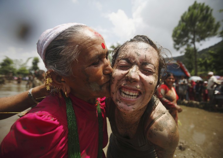 A Nepalese woman kisses a tourist while celebrating Asar Pandhra festival in Pokhara valley, west of Nepal's capital Kathmandu on June 29. Farmers in Nepal celebrate the festival to mark the commencement of rice crop planting in paddy fields.