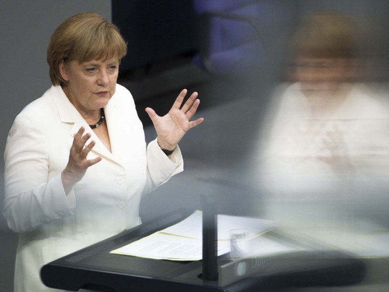 German Chancellor Angela Merkel addresses lawmakers on the decisions of the EU summit at the parliament Bundestag in Berlin Friday, June 29. Chancellor Merkel faces a vote on the eurozone's new permanent rescue fund and the EU's fiscal co-pact. Merkel is reflected in the windows of a visitors balcony at the plenary hall.