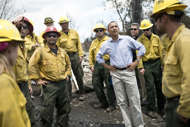 US President Barack Obama pauses with fire fighters while touring the Mountain Shadow neighborhood which was burned by wildfires about 72 hours ago, on June 29, 2012 in Colorado Springs, Colorado. Obama, who declared a major disaster in Colorado and offered federal assistance, is in the Colorado Springs area to survey wildfire damage and efforts to contain the natural disaster.