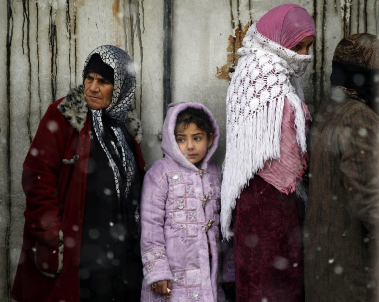 Women wait to buy bread in front of a bakery shop during winter in Al Qusayr, a city in western Syria about 4.8km (3 miles) southwest of Homs, March 1, 2012. REUTERS/Goran Tomasevic (SYRIA - Tags: SOCIETY FOOD)