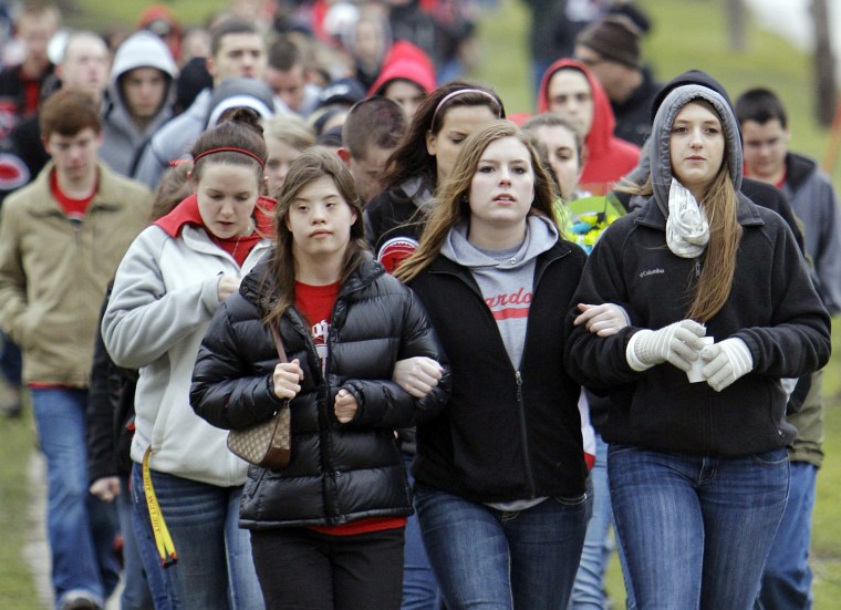Students and parents march to the high school in Chardon, Ohio, Thursday, March 1, 2012 to honor the three students who were killed in a shooting there Monday, Feb. 27. The school re-opened to parents and students Thursday and classes resume Friday. (AP Photo/Mark Duncan)