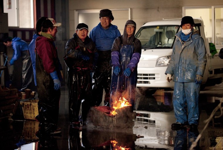 epa03129151 (10/20) Aquafarmers warm themselves by a fire during a break as they shell oyster harvested off the tsunami-devastated fishing port town of Yamada, Iwate Prefecture, northern Japan, before sunrise, 15 February 2012. As a result of the tsunami on 11 March 2011, 770 of about 17,000 residents were either killed or recorded missing. Aqua farming which is the main industry in the town was devastated by the tsunami. Many aqua farmers lost their houses, fishing vessels, farming rafts and fishery workshops. The remaining oyster farmers decided to work together, pool resources and rebuild their business as a cooperative. EPA/KIMIMASA MAYAMA PLEASE SEE ADVISORY (epa03129141) FOR FULL FEATURE TEXT
