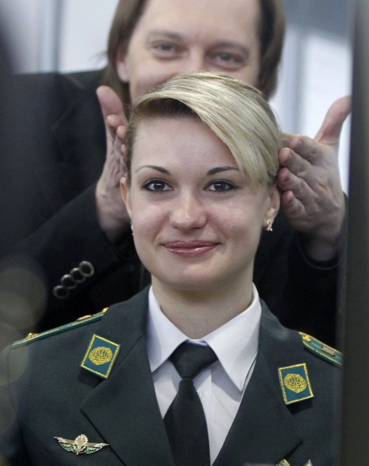 A Ukrainian border guard looks at her reflection in a mirror.