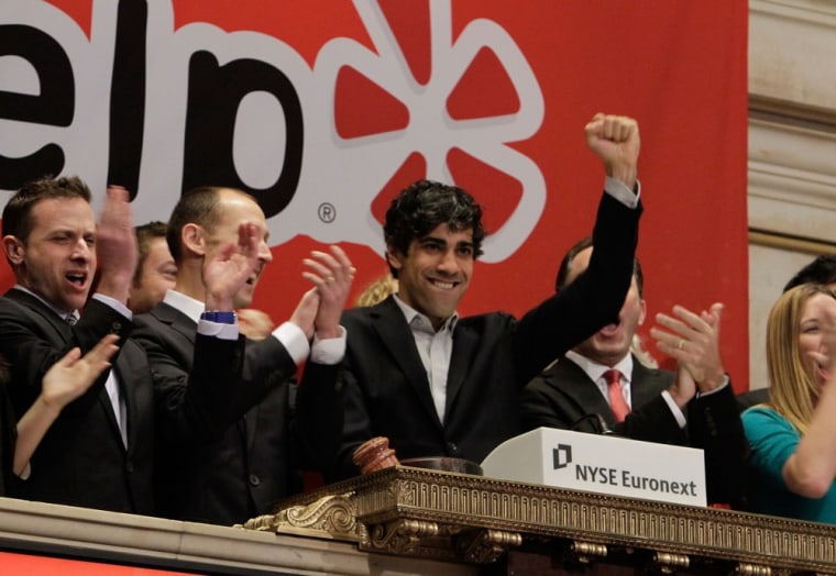 Jeremy Stoppelman, right center, Yelp co-founder and CEO, salutes during opening bell ceremonies of the New York Stock Exchange Friday, March 2, 2012. Yelp's stock is soaring in its stock market debut Friday. The shares are up 61 percent to $24.15 in the first minutes of trading, after pricing at $15 on Thursday night. (AP Photo/Richard Drew)