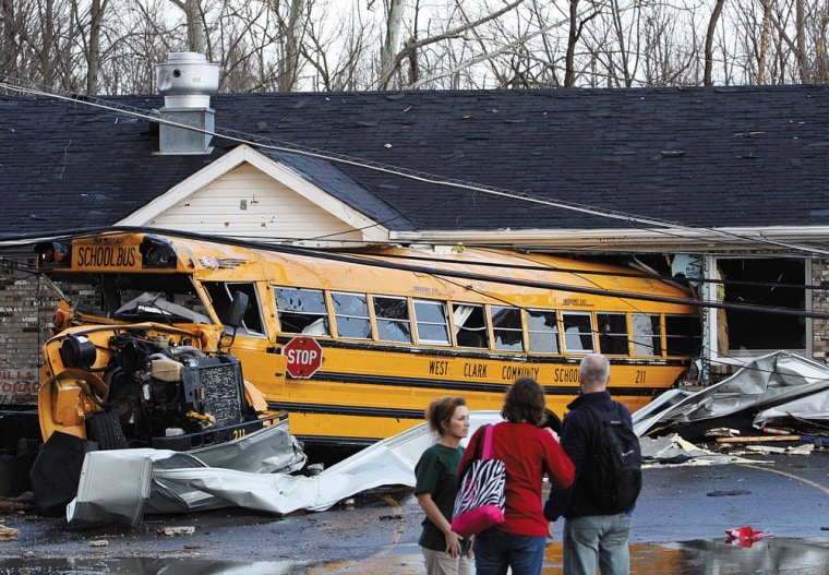 A school bus is crushed into a business on the east side of U.S. 31 in Henryville, Ind., after powerful storms stretching from the U.S. Gulf Coast to the Great Lakes in the north wrecked two small towns and killed at least eight people Friday, March 2, 2012, as the system tore roofs off schools and homes and damaged a maximum security prison. It was the second deadly tornado outbreak this week. (AP Photo/The News and Tribune, C.E. Branham)