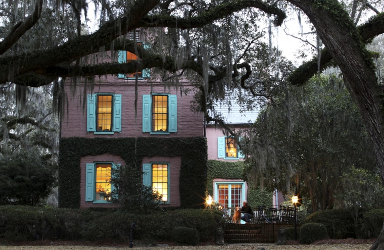 Medway Plantation property manager Bob Hortman and his dog Cooper, stand by the main plantation house in Goose Creek, South Carolina, February 17, 2012. Hortman has lived and worked on the property for 34 years and oversees the day-to-day operations and maintenance of the plantation. Medway Plantation has 6728 total acres of land with 50 miles of maintained roads. The main building was built in 1686 and is the oldest brick structure in South Carolina. In the South Carolina Lowcountry, more than a half-dozen antebellum plantations, which don't change hands often, are for sale. Picture taken February 17, 2012. REUTERS/Randall Hill (UNITED STATES - Tags: REAL ESTATE BUSINESS SOCIETY TRAVEL)