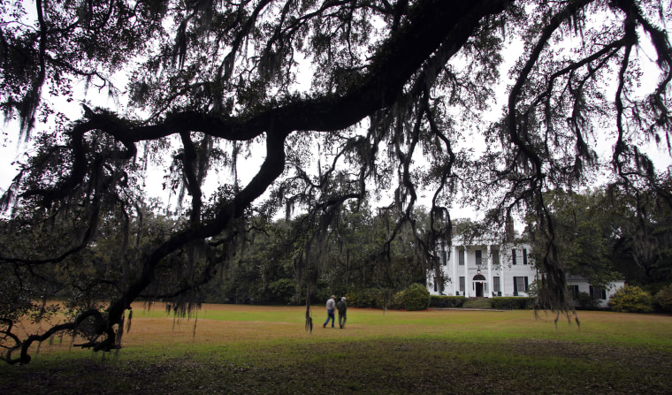 Realtor Chip Hall of Plantation Services, Inc. and Friendfield Plantation grounds manager Ed Carter walk to the main house at Friendfield Plantation in Georgetown, South Carolina, February 17, 2012. The main plantation house at Friendfield was built in 1790 but burned in the 1920s. This house was built in 1930 on the foundation of the original plantation house. In the South Carolina Lowcountry, more than a half-dozen antebellum plantations, which don't change hands often, are for sale. Picture taken February 17, 2012. REUTERS/Randall Hill (UNITED STATES - Tags: REAL ESTATE BUSINESS SOCIETY TRAVEL)