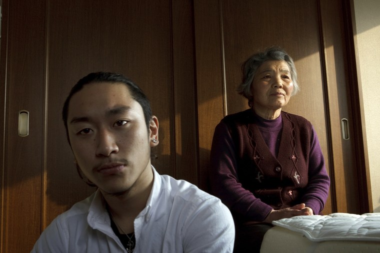 Jun Hirayama, 20, left, and his grandmother, Akiyo, 70, pose at their apartment in Sendai, Japan on Feb 21, 2012. A Massive earthquake and tsunami swept their house away on March 11, 2011. After the tsunami overtook the car they were driving, Akiyo spent a night on the roof of the half-submerged vehicle while Jun hung onto a tire drifting in freezing waters. Photo by Kuni Takahashi