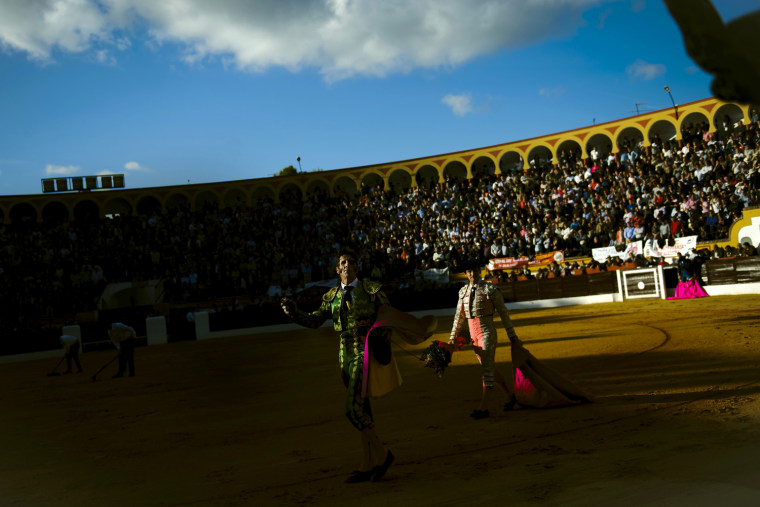 Spanish bullfighter Juan Jose Padilla, left, is greeted by the audience during a bullfight in the southwestern Spanish town of Olivenza, Sunday, March 4, 2012. Padilla, who lost sight in one eye and has partial facial paralysis after a terrifying goring returned to the bullring Sunday, five months after his injury. (AP Photo/Daniel Ochoa de Olza)