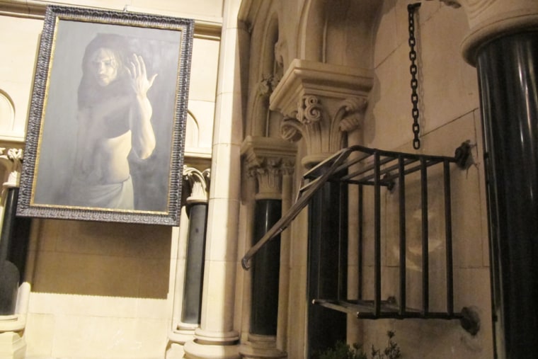 The iron cage that housed the heart of St. Laurence O'Toole sits broken and empty Sunday, March 4, 2012, inside Christ Church Cathedral in Dublin. A modern portrait of Jesus Christ is in the background. (AP Photo/Shawn Pogatchnik)