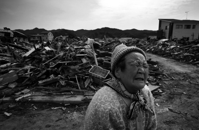 Fukuko Hatakeyama, 80, weeps near the debris of her house in Kesennuma, Miyagi, Japan on March 29, 2011, following a massive earthquake and tsunami that hit northern Japan on March 11, sweeping away her house and all her belongings, including cash savings for her son. Photo by Kuni Takahashi