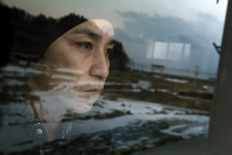 Masanori Sato, 34, looks at the empty land which his village used to be in Minamisanriku, Miyagi, Japan on Feb 4, 2012, outside his half destroyed house. Massive earthquake and tsunami hit northern Japan on March 11, 2011, sweeping away 34 houses in the village. Only three survived including his house. Photo by Kuni Takahashi