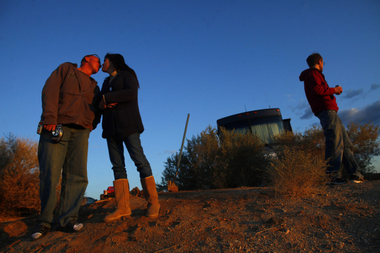 ATTENTION EDITORS: PICTURE 30 OF 30 FOR PACKAGE 'LIFE IN SLAB CITY' Rob Walker (L) kisses Dayna Lambert as Walker's son Andy walks toward their campsite in Slab City just outside Niland, California February 16, 2012. Walker said he retired and bought a motor home, and has mixed Slab City into his travelling destinations. A former military base that was closed after World War II, Slab City is a place on the fringe both geographically and philosophically and attracts a variety of people, including jobless and financially struggling recession refugees who can no longer pay for food and housing. Picture taken February 16, 2012. REUTERS/Eric Thayer (UNITED STATES - Tags: SOCIETY)