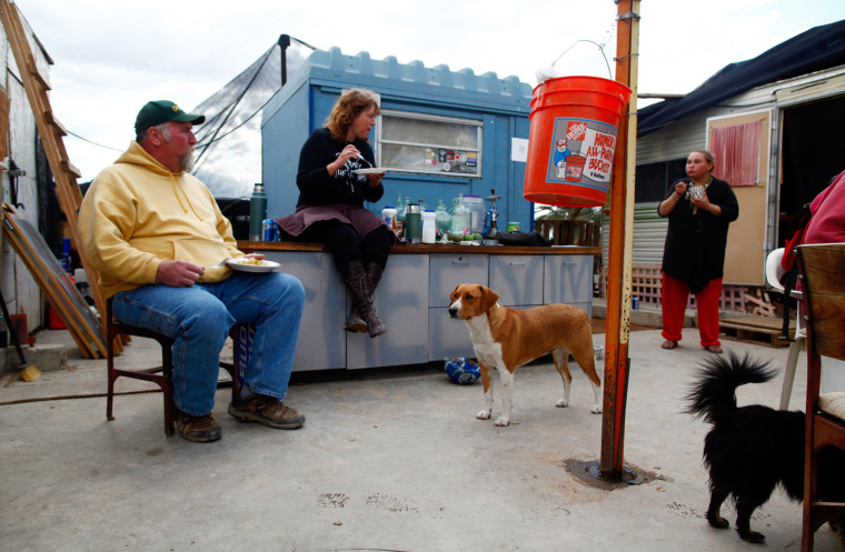 ATTENTION EDITORS: PICTURE 14 OF 30 FOR PACKAGE 'LIFE IN SLAB CITY' People eat lunch in Slab City just outside Niland, California February 16, 2012. A former military base that was closed after World War II, Slab City is a place on the fringe both geographically and philosophically and attracts a variety of people, including jobless and financially struggling recession refugees who can no longer pay for food and housing. Picture taken February 16, 2012. REUTERS/Eric Thayer (UNITED STATES - Tags: SOCIETY)