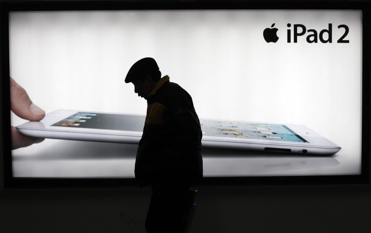 A man walks past an advertisement of Apple's iPad 2 on Tuesday, Feb. 28, 2012 in Shanghai, China. Proview Electronics said it is now seeking to regain worldwide rights to the iPad name and is suing Apple Inc. for alleged fraud and unfair competition, hoping to have a 2009 sale of the trademark ruled void. (AP Photo/Eugene Hoshiko)