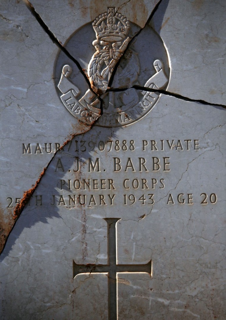 The headstone of A.J. M. Barbe, a soldier of pioneer corps who died Jan 25, 1943 is seen broken at the Commonwealth Benghazi War Cemetery holding the remains of British and Commonwealth soldiers who fought during the second world war in the north African desert battles, after it was desecrated by a mob of angry Libyans days earlier. Local reports claimed the group were Islamists angered by the recent burning of a Koran at a NATO military base in Afghanistan. Libya's national transitional government has apologised for the attacks and local authorities have detained several suspects. (AP Photo/Manu Brabo)