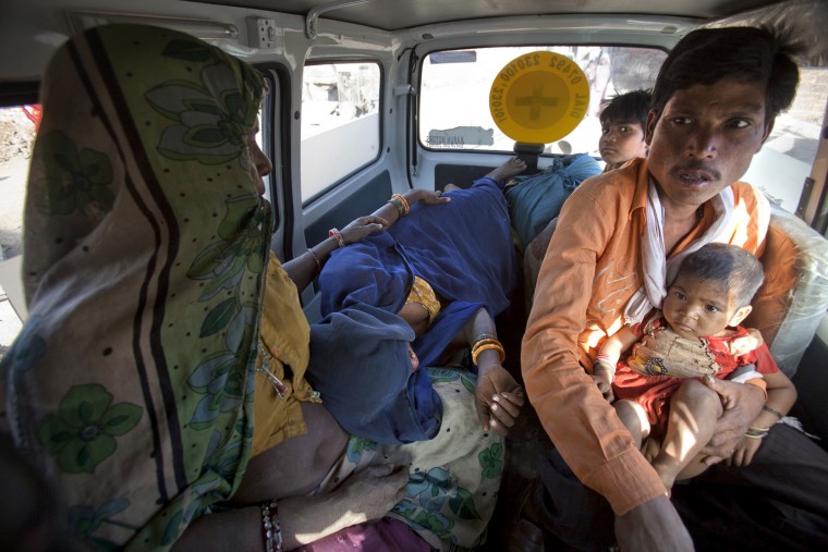 Anguri (in blue sari), a 26-year-old pregnant woman in labour, lies on a bench inside a maternity ambulance as her relatives accompany her to a community health centre in a rural area near the remote village of Chharchh, in the central Indian state of Madhya Pradesh, February 24, 2012. In rural Madhya Pradesh, an innovative and free maternity ambulance service called