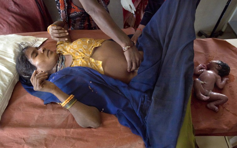Anguri, a 26-year-old woman in labour, lies on a maternity table as she gives birth to a baby girl at a community health centre in the remote village of Chharchh, in the central Indian state of Madhya Pradesh, February 24, 2012. In rural Madhya Pradesh, an innovative and free maternity ambulance service called