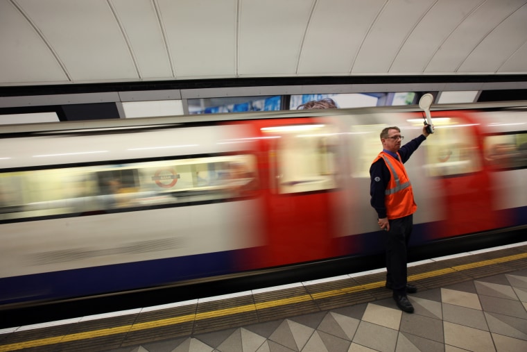 LONDON, ENGLAND - MARCH 05: A conductor signals the departure of a train at an Underground station on March 5, 2012 in London, England. London's underground rail system, commonly called the tube, is the oldest of its kind in the world dating back to 1890. It carries approximately a quarter of a million people around its network every day along its 249 miles of track and 270 stations. The network has undergone several years of upgrade work and refurbishment in preparation for the Olympic Games which take place this summer. During this time the tube is expected to carry millions of visitors to and from the Olympic Parks. (Photo by Dan Kitwood/Getty Images)