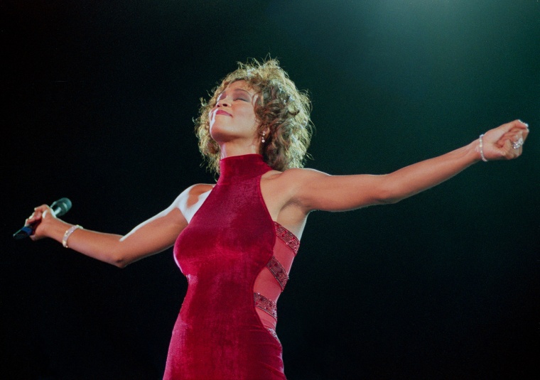 Whitney Houston performs on stage in 1996. (Photo by Phil Dent/Redferns)