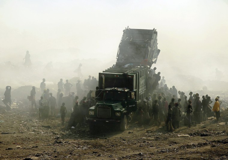 PORT-AU-PRINCE, HAITI - MARCH 07: Children and adults scavenge for recyclables and other usable items around a garbage truck at the Trutier dump on the outskirts of Port-au-Prince, on March 7, 2012 in Port-au-Prince, Haiti. Following the devastating earthquake two years ago that killed and estimated 316,000 people, the number of scavengers at the landfill has grown from about 200 to an estimated 2,000. Much of Haiti is still in a crisis situation with tens of thousands living in tent camps in and around Port-au-Prince. A growing concern to international donors is a flare-up between ex-members of Haiti's armed forces and the current Haitian President Michel Martelly. (Photo by Spencer Platt/Getty Images)