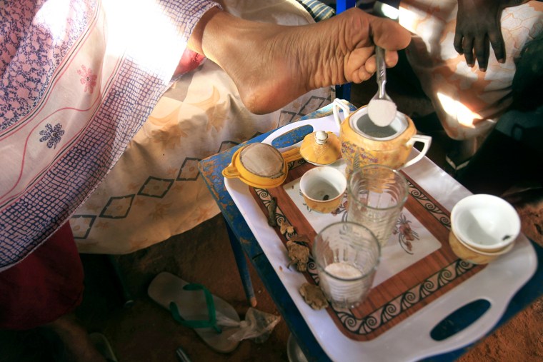 Hokom Al, a disabled woman, uses her foot to hold a spoon of sugar as she makes coffee for neighbours at her home in a rural area in Khartoum March 7, 2012. Hokom Al, 45 years old, was born without hands. International Women's Day takes place on March 8. REUTERS/Mohamed Nureldin Abdallah (SUDAN - Tags: SOCIETY HEALTH)