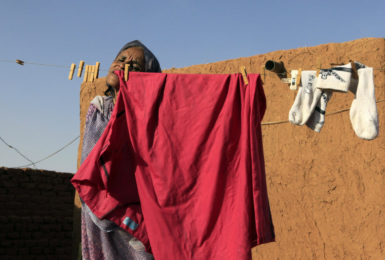 Hokom Al, a disabled woman, uses her mouth to hang clothes to dry in a rural area in Khartoum March 7, 2012. Hokom Al, 45 years old, was born without hands. International Women's Day takes place on March 8. REUTERS/Mohamed Nureldin Abdallah (SUDAN - Tags: HEALTH SOCIETY)