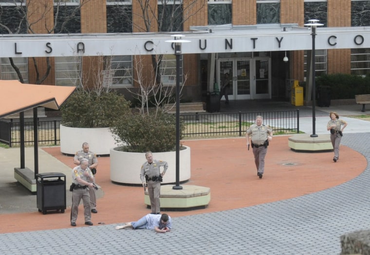 Tulsa County sheriff's deputies and other law enforcement officers secure a gunman on the plaza in front of the Tulsa County courthouse in Tulsa, Oklahoma, March 7, 2012. The gunman was