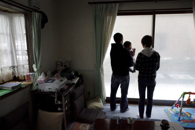 Koya Takahashi, left, and his wife, Megumi, with their son, Nagato, 11month, looks outside their house in Minamisanriku, Miyagi, Japan on Feb 26, 2012. Nagato was born six days after the massive earthquake and tsunami hit northern Japan on March 11, 2011, sweeping away many coastal towns including Minamisanriku. Photo by Kuni Takahashi