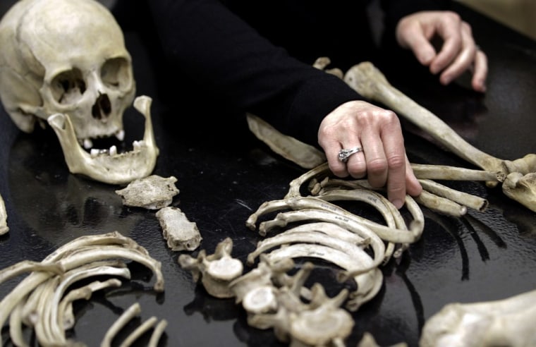 Kate Spradley, an assistant professor at Texas State University, arranges some skeletal remains at the school's Forensic Anthropology Research Facility, Thursday, Feb. 9, 2012, in San Marcos, Texas. What they're finding at the research facility debunks some of what they and other experts believed about estimating time of death for a person whose remains are found outdoors and exposed to the environment. (AP Photo/David J. Phillip)