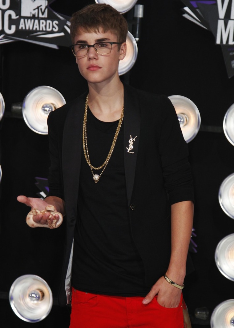 Singer Justin Bieber arrives holding a snake in his hand at the 2011 MTV Video Music Awards in Los Angeles August 28, 2011. REUTERS/Danny Moloshok (UNITED STATES - Tags: ENTERTAINMENT ANIMALS) (MTV-BACKSTAGE)