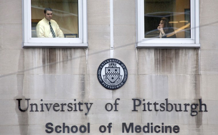 Two people wait to leave the University of Pittsburgh School of Medicine after the area was locked down by police due to a shooting at the Western Psychiatric Institute and Clinic of University of Pittsburgh Medical Center in Pittsburgh, Pennsylvania March 8, 2012. Two people were killed in the shooting on Thursday, and one of the dead was believed to be the shooter, the hospital said. REUTERS/ Jason Cohn (UNITED STATES - Tags: CRIME LAW CIVIL UNREST)