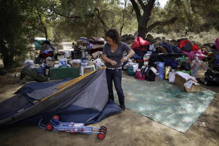 Angelica Cervantes, 36, packs up tents in the campground where she has been staying with her aunt Benita Guzman, 40, and their children, in Santa Paula.