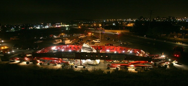 A 340-ton boulder is hoisted onto a giant trailer move along Granite Hill Drive early Wednesday Feb. 29 in Jurupa Valley, Calif.
