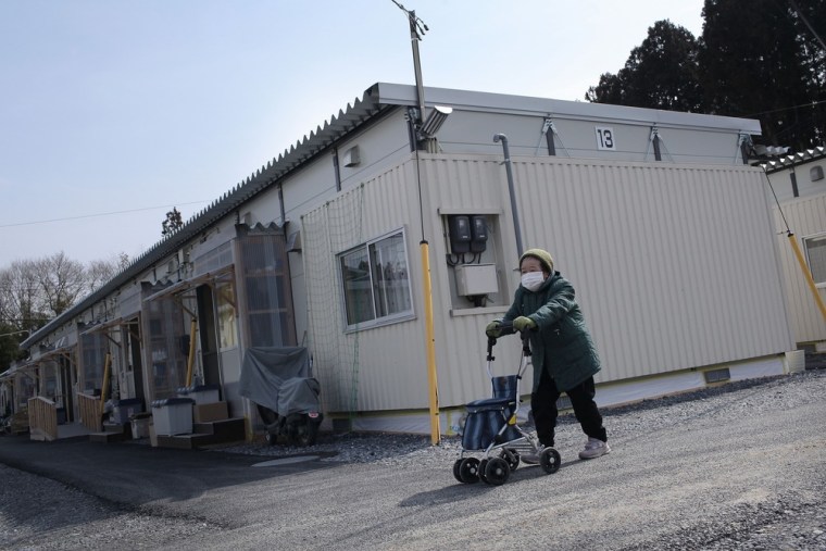RIKUZENTAKATA, JAPAN - MARCH 09: Sakae Niinuma, 81, walks laps up and down a road outside her home in a temporary housing community on March 9, 2012 in Rikuzentakata, Japan. Mrs Niinuma and her husband lost their home to the March 11th tsunami with her husband hospitalized with an unrelated medical condition Mrs Niinuma walks to keep fit and says it helps her bad back. As the one year anniversary approaches, the areas most affected by an earthquake and subsequent tsunami that left 15,848 dead and 3,305 missing according to Japan's National Police Agency, continue to struggle. Thousands of people still remain without homes and are living in temporary dwellings. The Japanese government faces an uphill battle with the need to dispose of rubble as it works to rebuild economies and livelihoods. (Photo by Chris McGrath/Getty Images)