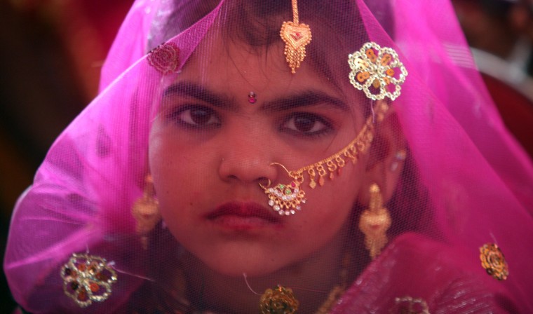 A veiled girl from the Saraniya community waits for her engagement ceremony to start at Vadia village in the western Indian state of Gujarat March 11, 2012. The Vadia village in western India hosted a mass wedding and engagement ceremony of 21 girls on Sunday aimed at breaking a tradition of prostitution which has for centuries exploited women of a poor, marginalised and once nomadic community in the region. REUTERS/Amit Dave (INDIA - Tags: SOCIETY)