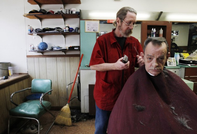 Charles Comas, owner of Comas Family Barber Shop on Main Street in Wheeling, West Virginia, finishes giving a hair cut to regular customer John Oliver March 6, 2012. Oliver, who has lived in Wheeling his whole life, remembers when the now sparsely occupied downtown was so packed with people