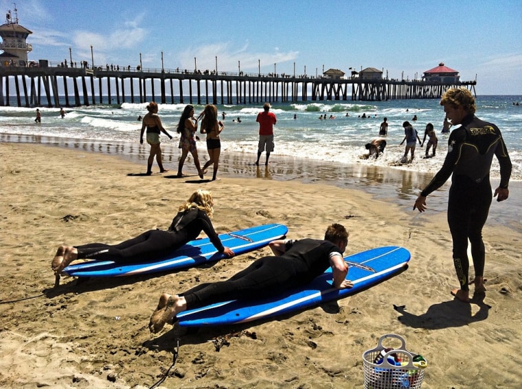 Sandra Foyt's 15-year-old daughter and another student get a surfing lesson from Zack's Surf Shop in Huntington Beach, Calif.