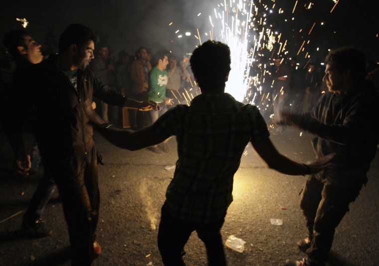 Joyful Iranian men dance around a firework, in the Pardisan Park in Tehran, Iran, Tuesday, March 13, 2012, during Chaharshanbe Souri, or Wednesday Feast, an ancient Festival of Fire, on the eve of the last Wednesday of the year. Iranians jump over burning bonfires while throwing firecrackers, celebrate arrival of the spring which coincides with Iranian new year, or Nowruz. Setting off firecrackers has turned into careless massive explosions in the recent years, which leaves many wounded every year, prompting strong reactions by police. The festival, came from pre-Islamic Zoroastrianism era, has been discouraged by conservative Islamist rulers after 1979 Islamic Revolution, but without any success. (AP Photo/Vahid Salemi)