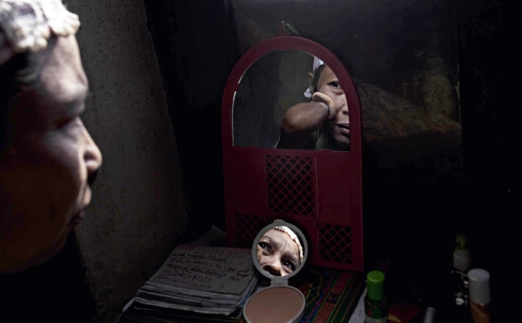 PURWOREJO, INDONESIA - MARCH 13: Armless professional photographer Rusidah, 44, puts on her make-up on March 13, 2012 in Purworejo, Indonesia. Rusidah shoots weddings and parties and has a small studio at home in the village of Botorejo, Bayan District, Purworejo, Central Java where her husband and son also reside. She has been in the photography business for nearly 20 years. (Photo by Ulet Ifansasti/Getty Images) *** BESTPIX ***