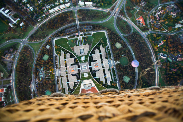 epa03143665 View of the Australian Federal Parliament House from a hot air balloon above Canberra, Australia, 14 March 2012. The Balloon Spectacular is one of the major events of the Canberra Festival and is listed as one of the top four hot ballooning events in the world. EPA/LUKAS COCH AUSTRALIA AND NEW ZEALAND OUT