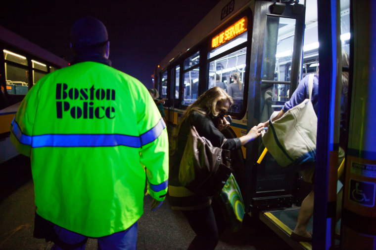 A police officer helps load city buses after a transformer fire sent black smoke into streets and plunged parts of the city into darkness in the Back Bay section of downtown Boston March 13, 2012. A three alarm fire caused power problems as citizens were warned to avoid the area avoid breathing the smoke according to officials. REUTERS/Scott Eisen (UNITED STATES - Tags: ENERGY SOCIETY TPX IMAGES OF THE DAY)
